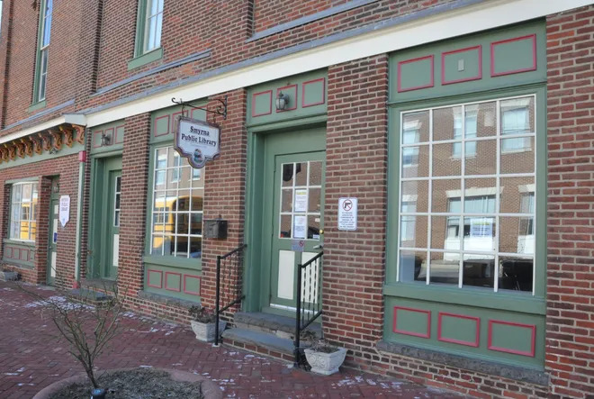 An image of the front door and windows of the Smyrna Public Library.